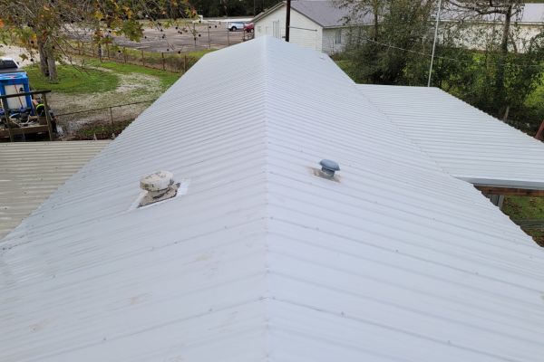 The roof of a house shown clean and well-maintained, with a bright, refreshed appearance after roof washing services.