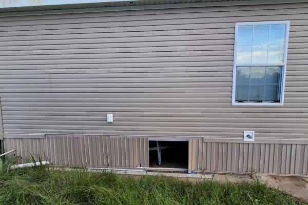 The exterior of a house with clean, well-maintained siding and a window, showing an improved appearance after washing services.
