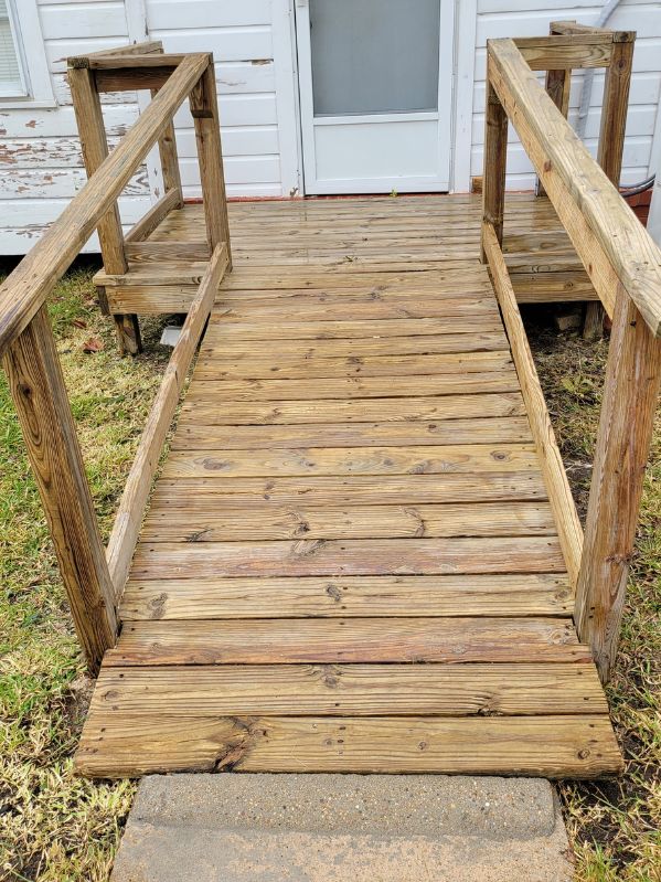 Refurbished and cleaned wooden ramp with uniform, bright wood color and restored railing, showing a polished and refreshed appearance.