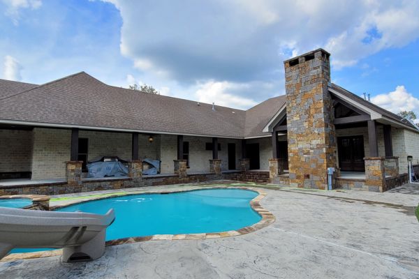 The same backyard pool area with the concrete surface looking freshly cleaned and much brighter, free from stains and dirt, showing a much more well-maintained and pristine appearance.