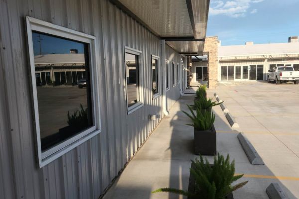 After concrete washing services, showing a clean and polished concrete surface with newly washed planters and building exterior, reflecting a bright, neat environment.