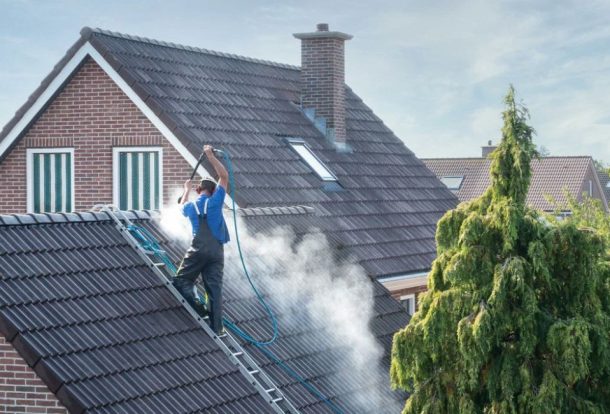 Roof washing services professional cleaning a tiled roof using safe, low-pressure washing to remove dirt, moss, and stains.